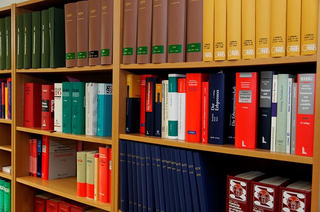 Six wall shelves filled with thick law books with gold, brown, red and white binders