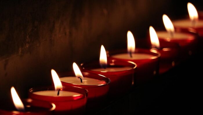 Lighted red votive candles in a line