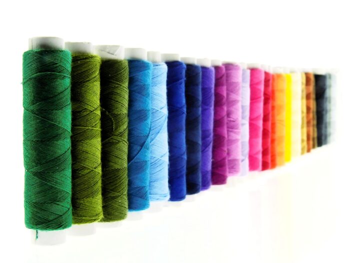 Embroidery thread spools in rainbow colors in a line