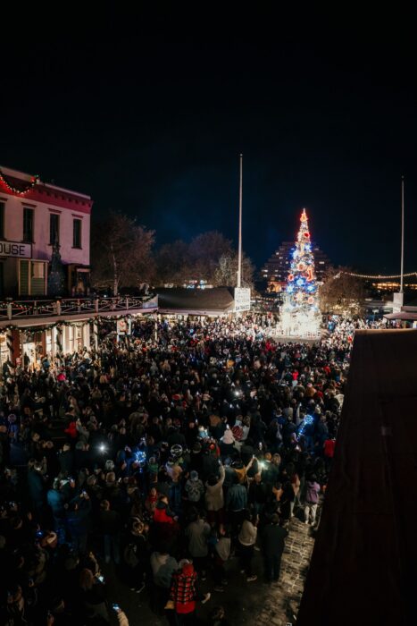 Lighted Christmas tree in Old Sacramento with crowds of people nearby