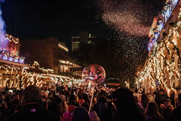 Snow sprays into the nighttime sky from lighted balconies as bystanders watch "Theatre of Lights" performance in Old Sacramento.