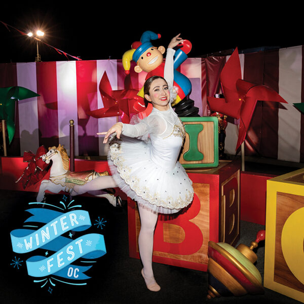 Ballerina in a white tutu dances en pointe near a background of blocks and toys with "Winterfest OC' on a blue banner in the lower left corner of the picture