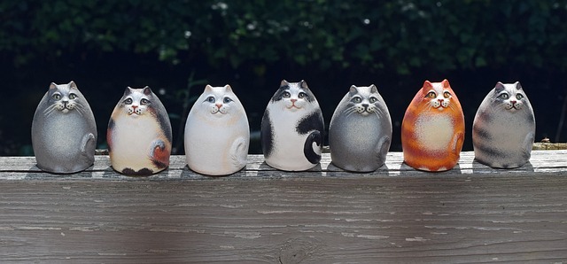 line of ceramic cats on an outdoor shelf