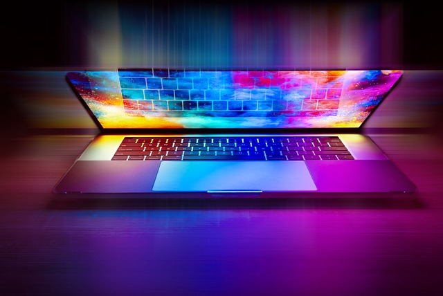 Laptop computer appears to "light up" in rainbow colors: turquoise, magenta, gold, and violet.