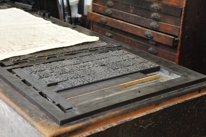 Rows of typeface letters on an antique printing press's plate.