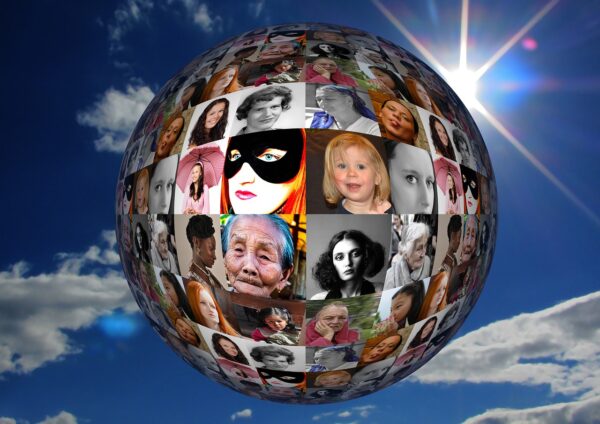 Photographs of faces of women and girls form a globe against a blue sky.