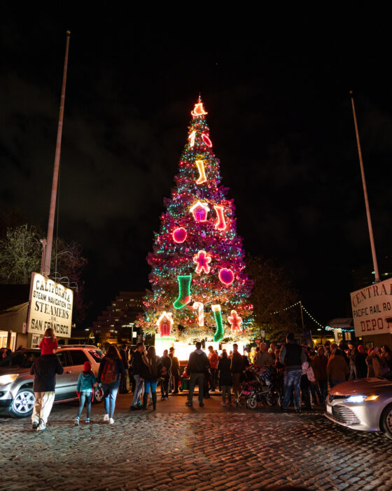 Lighted Christmas tree stands near historic buildings of Old Sacramento