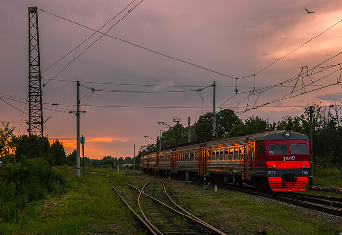 Vintage train on tracks at sunset.