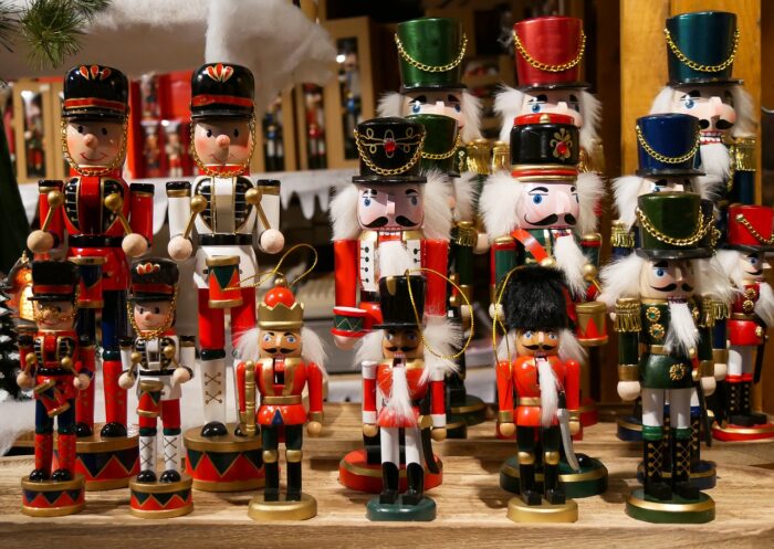 Array of carved nutcrackers and wooden soldiers stand on a shelf.