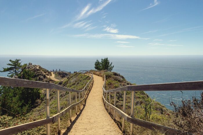 Railed walkway in Muir Beach leads along a cliff overlooking the ocean.
