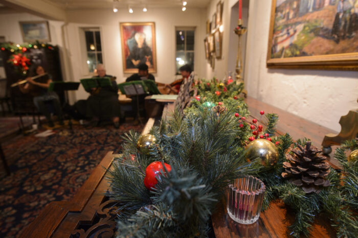 Adobe room decorated with greenery and red berries.