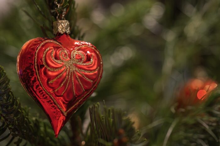 Red heart ornament on a Christmas tree