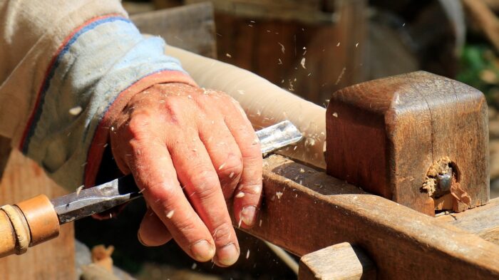 Closeup on artist's hand as he turns wood.