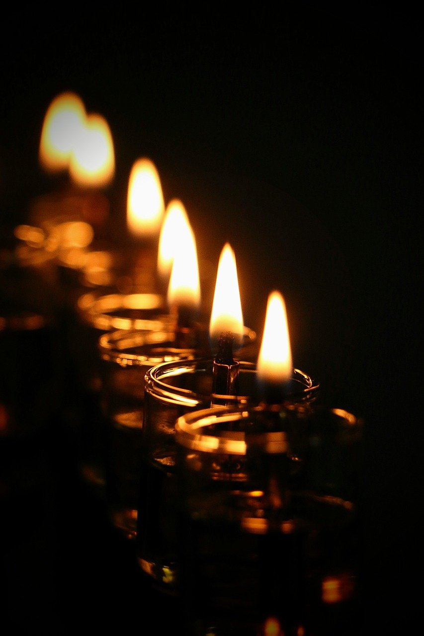 Closeup of lighted candles on Hanukkah menorah.