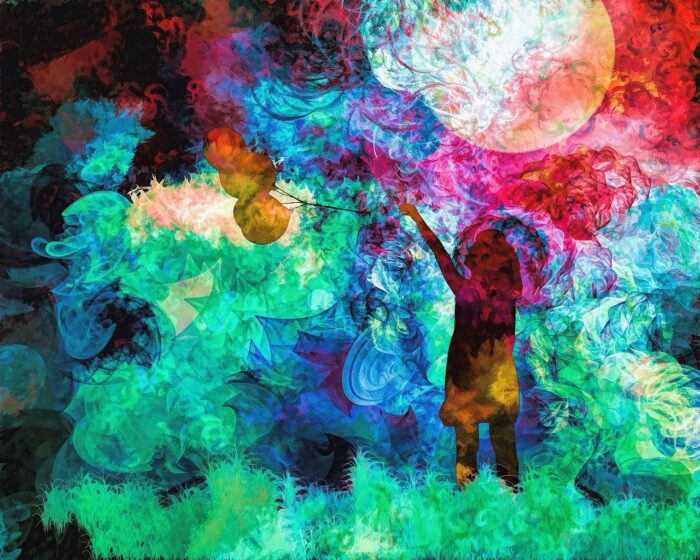 Small girl reaches out her arms towards an abstract of paing splashes of different colors surrounding her.