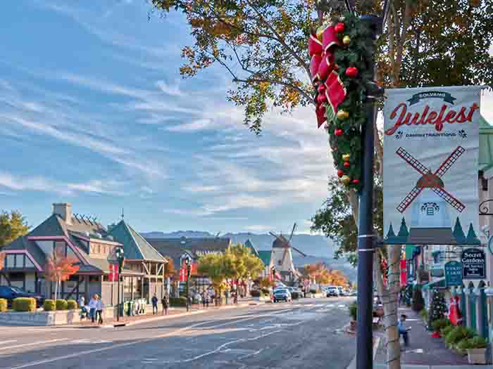 "Julefest" sign with red ribbon and greenery, on a post outside Solvang's main street.