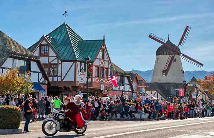 Mrs. Claus waves to spectiators from the back of a motorcycle during Julefest parade.