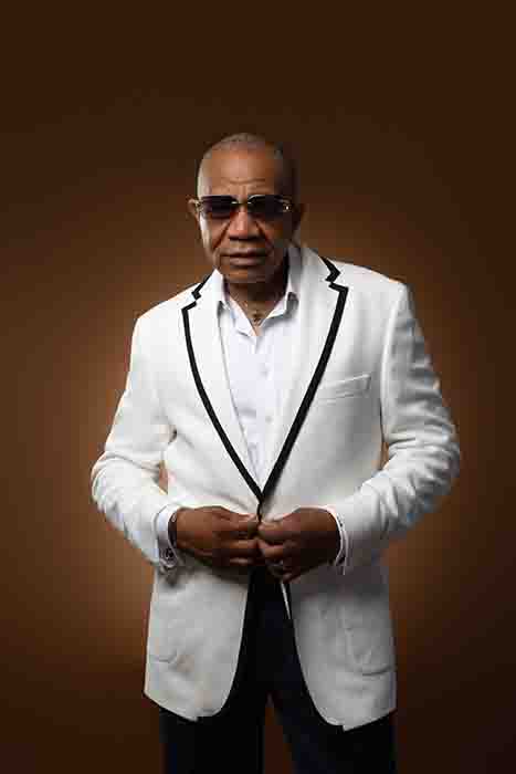 Legendary R&B crooner Lenny Williams, in a white tuxedo jacket with black piping and dark glasses.