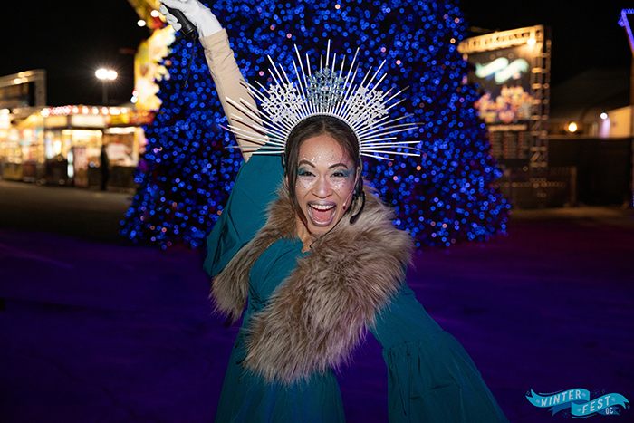 Smiling woman in an icicle crown against a background of gold lights