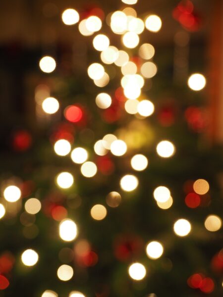 Blurred green Christmas tree with red and gold lights