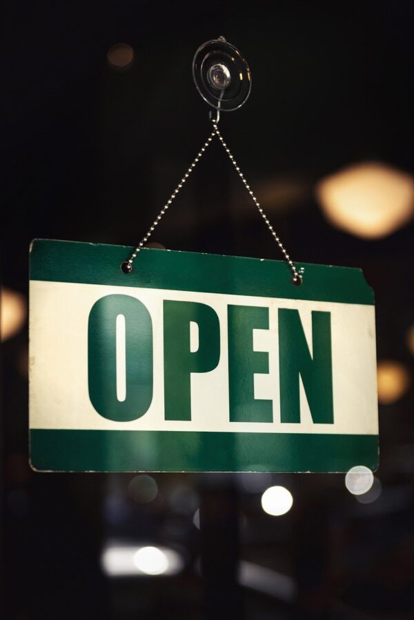 Sign on store door shows "OPEN" in green letters.