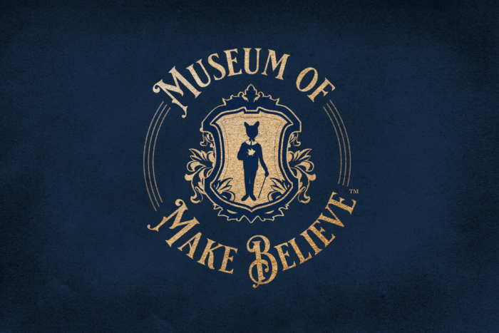 Museum of Make Believe graphic with cat in the center of a gold shield against a black background