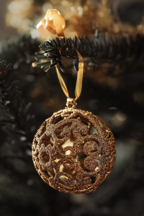 Gold filigree Christmas ornament on a pine branch