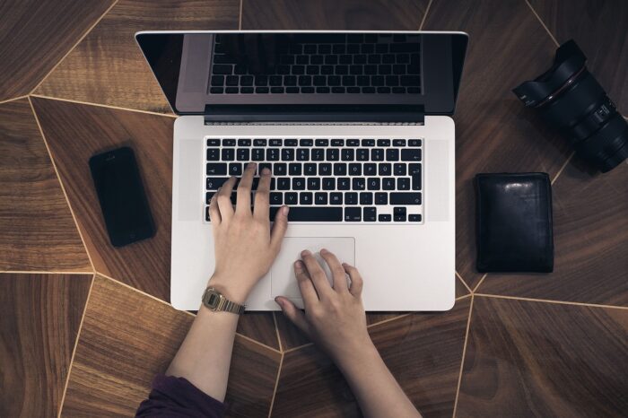 Young girl's hands typing on a laptop