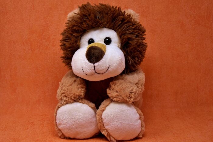 Smiling toy stuffed lion with furry brown mane