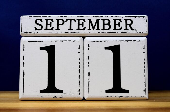 Wooden desk calendar shows, "September 11" in worn blocks.