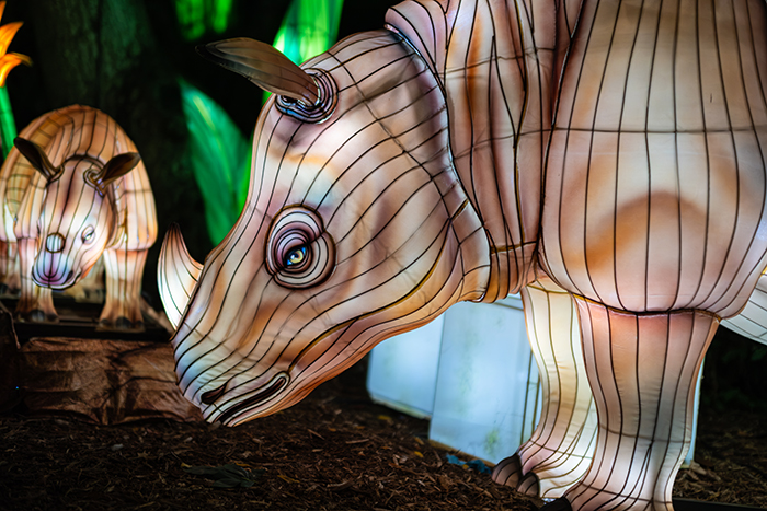 Closeup of two detailed rhinoceros-shaped lanterns with yellow eyes.