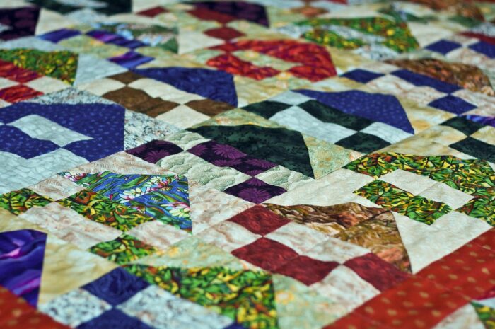 Closeup of patchwork quilt with multicolored triangles in a "tree" pattern