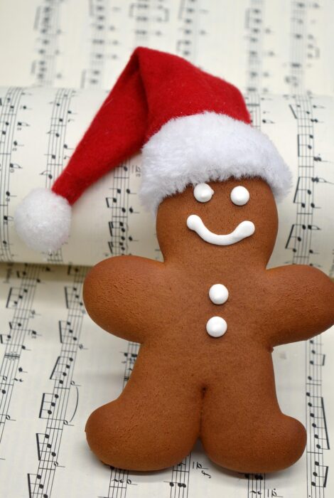 Gingerbread man in a Santa hat over a musical score