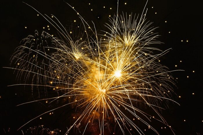 Gold fireworks with sparkles against a black sky