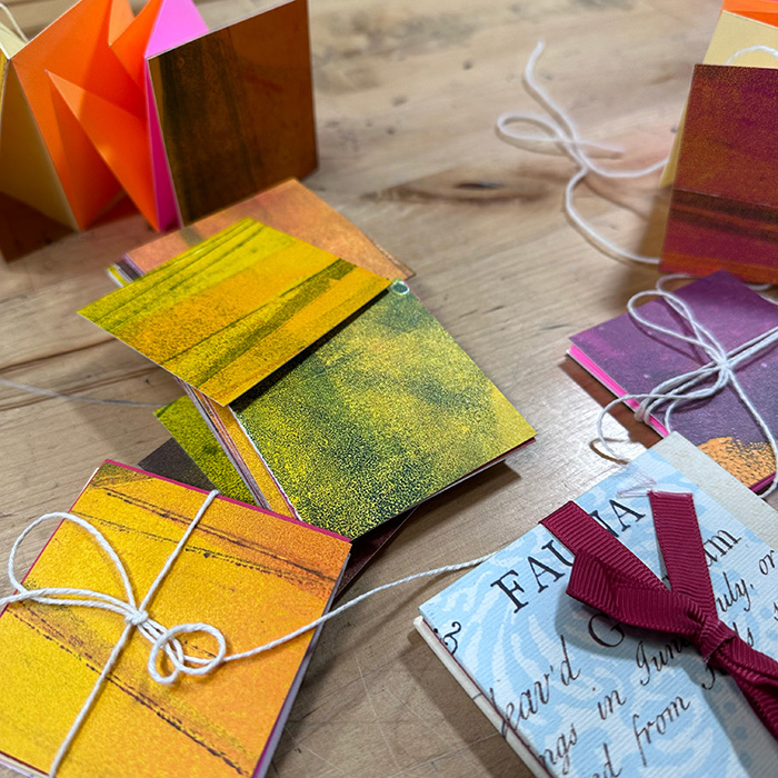 Multiple books bound in rainbow colors and a "flip book" with green and yellow pages.