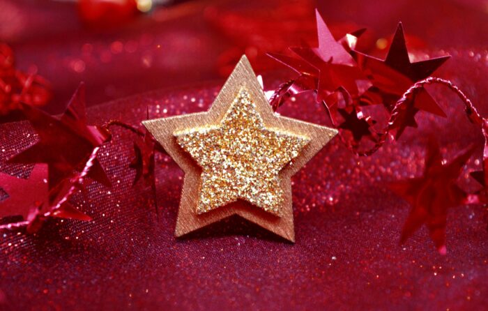 Gold star with glitter-foil center against a red background with red foil stars