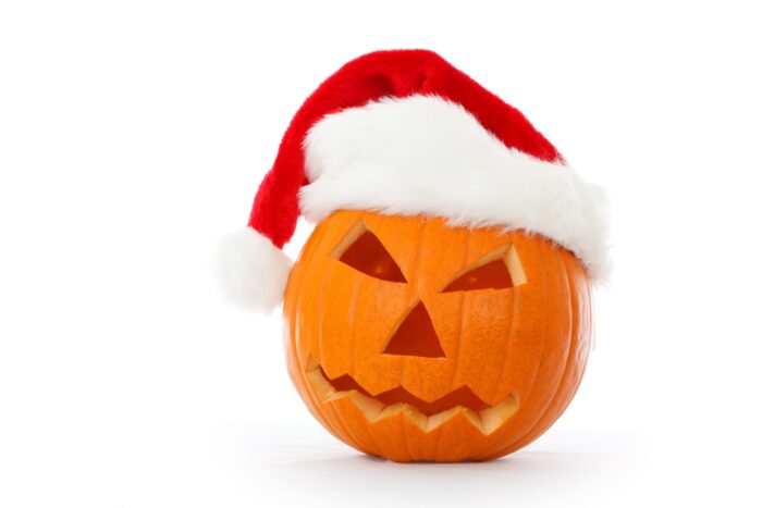Scowling jack-o-lantern wears a Santa hat